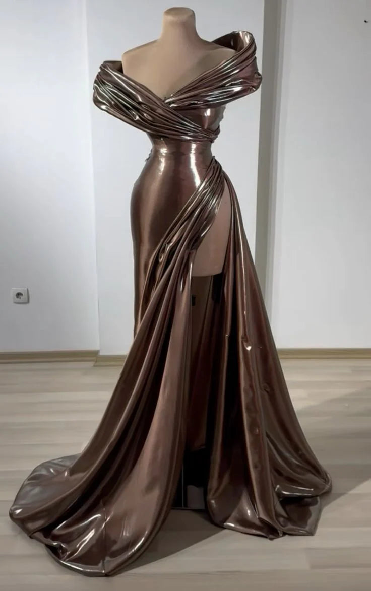 A brown dress with a metallic sheen, featuring an off shoulder deep V-design, paired with a high slit and a dangling tail