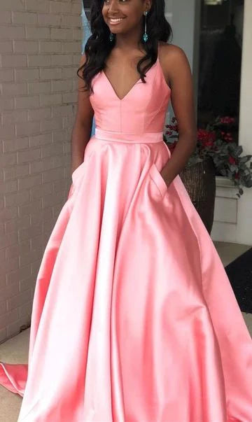 A light pink satin dress with a deep V-neck strap, high waist and large skirt, and pockets suitable for dinners, dances, and other occasions 