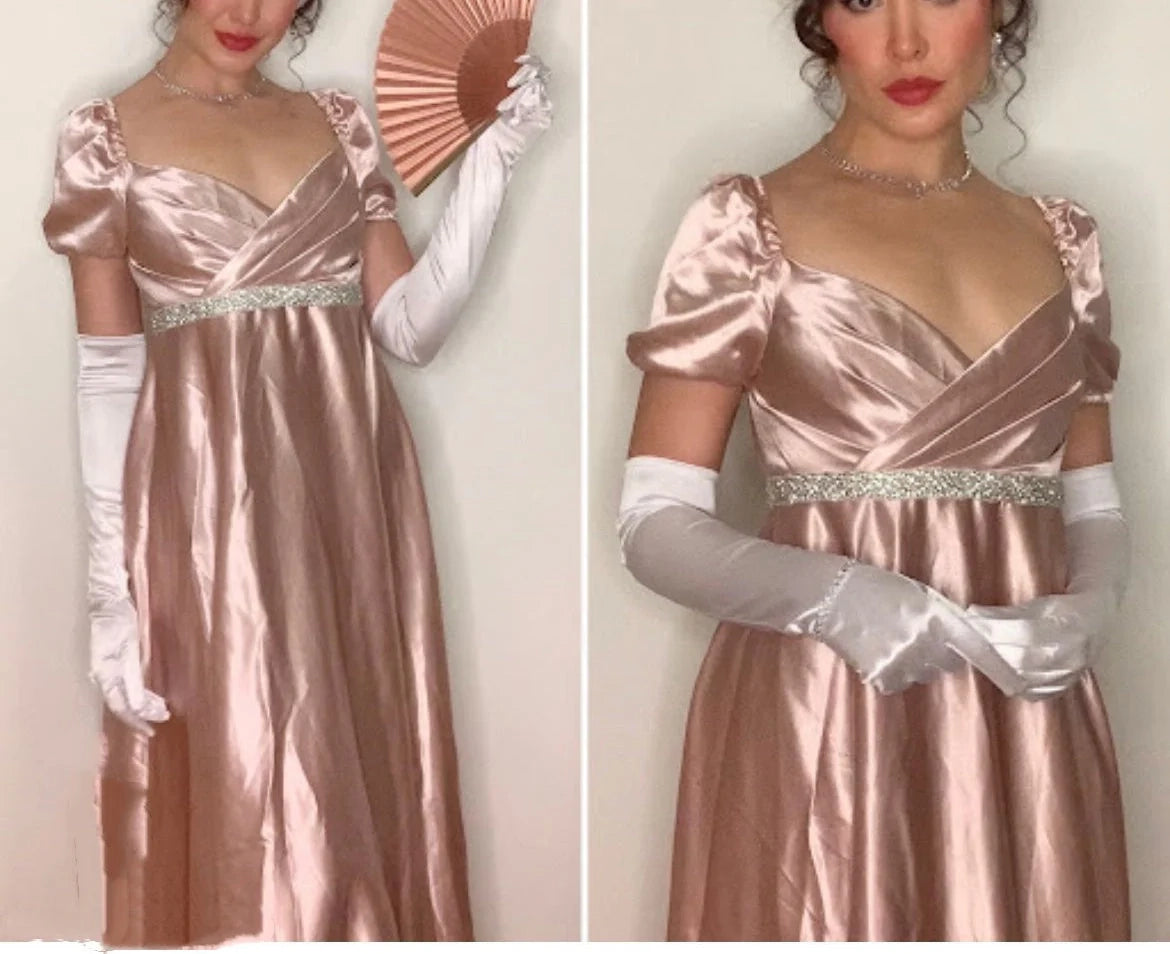 A light pink satin dress with a square neckline and bubble sleeves designed in a retro and elegant style, and a cross breasted rhinestone waistband outlining the curves,