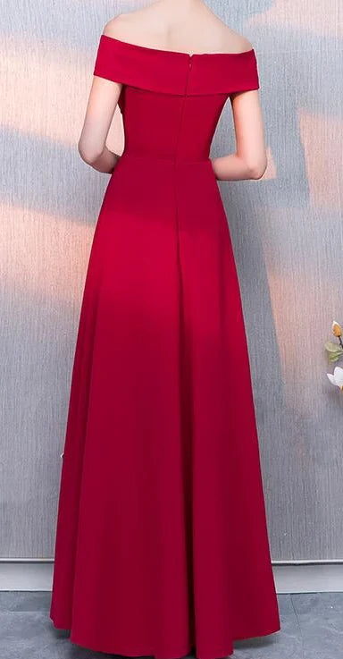 A red formal dress with a one shoulder design and a waist cinching hem, suitable for dinner parties