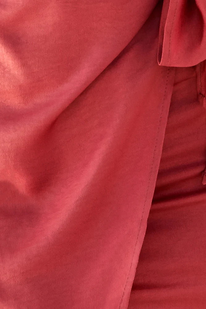 A short red brown one shoulder dress with a single shoulder design that exposes one side of the shoulder, neck, and waist. It is decorated with a tie bow and is suitable for dates, parties, and other occasions.