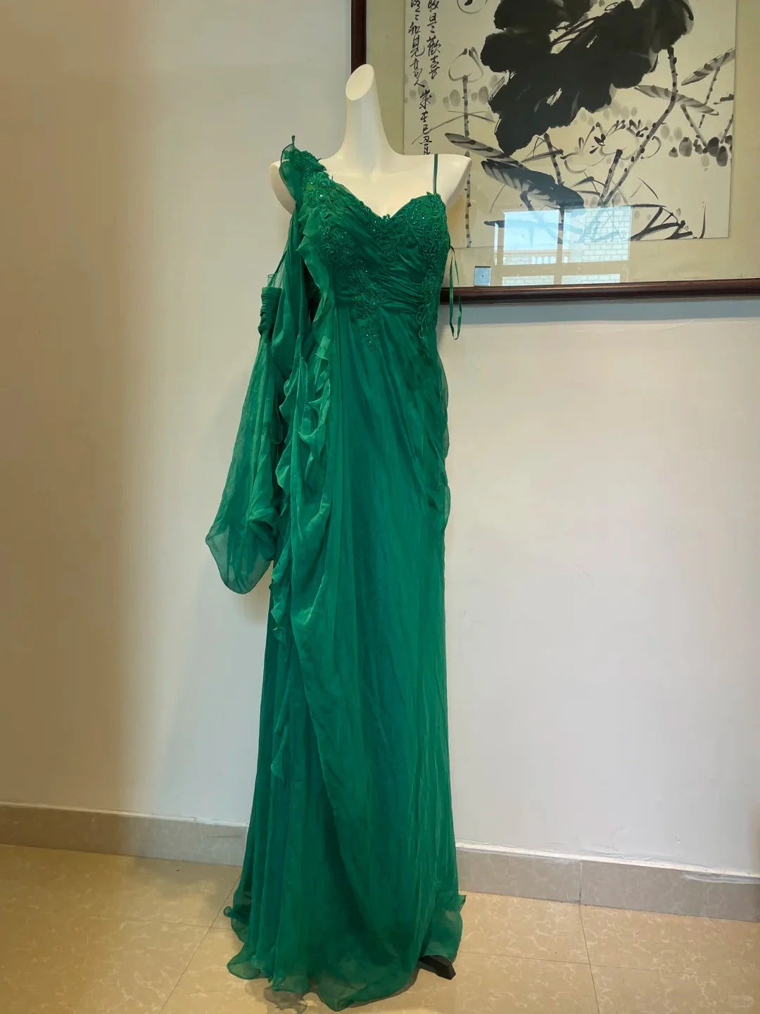Dark green dress, made of lightweight yarn fabric, with a deep V-neck and asymmetrical floating sleeves