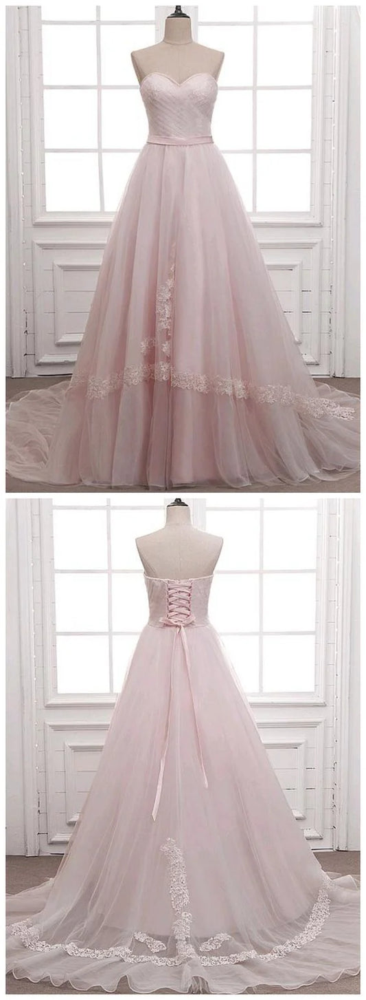 Light pink wedding dress with strapless design and sheer skirt with lace decoration