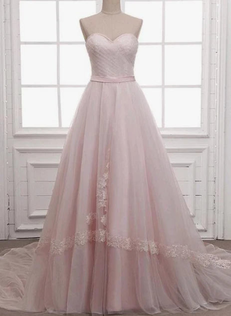 Light pink wedding dress with strapless design and sheer skirt with lace decoration