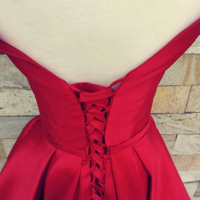 Wine red satin dress with a one shoulder design and a waist cinching hem suitable for dinner parties