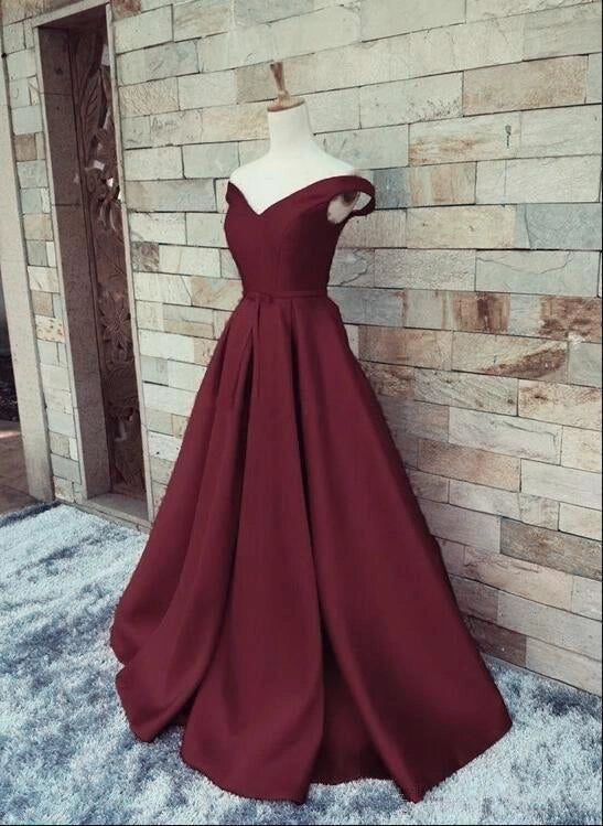 Wine red satin dress with a one shoulder design and a waist cinching hem suitable for dinner parties