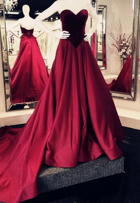 Wine red satin dress with strapless heart-shaped neckline, high waist, and large skirt with trailing hem, suitable for dinner parties