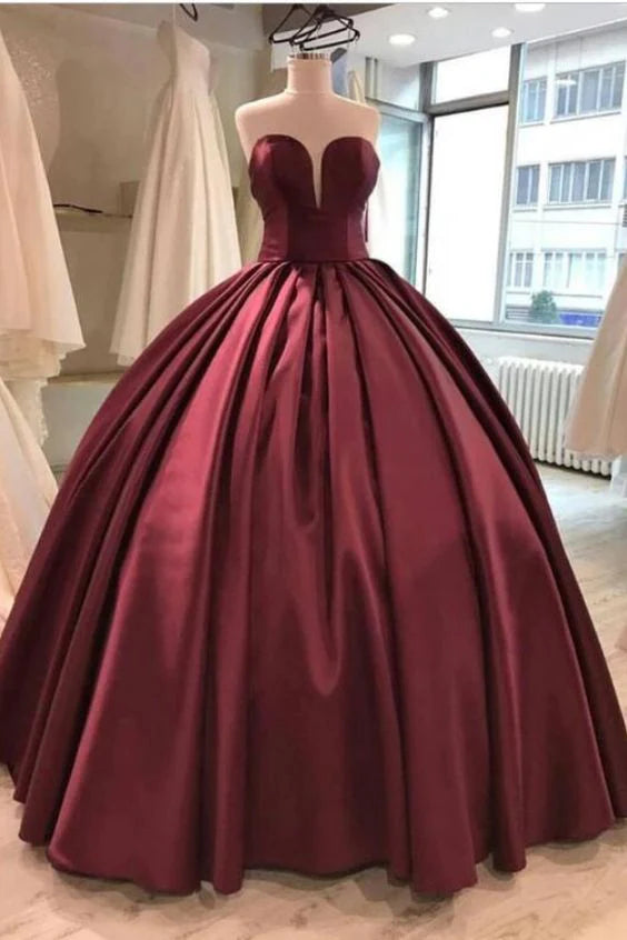 Wine red strapless dress with a large skirt and a voluminous lower body, suitable for formal occasions such as dinners and parties