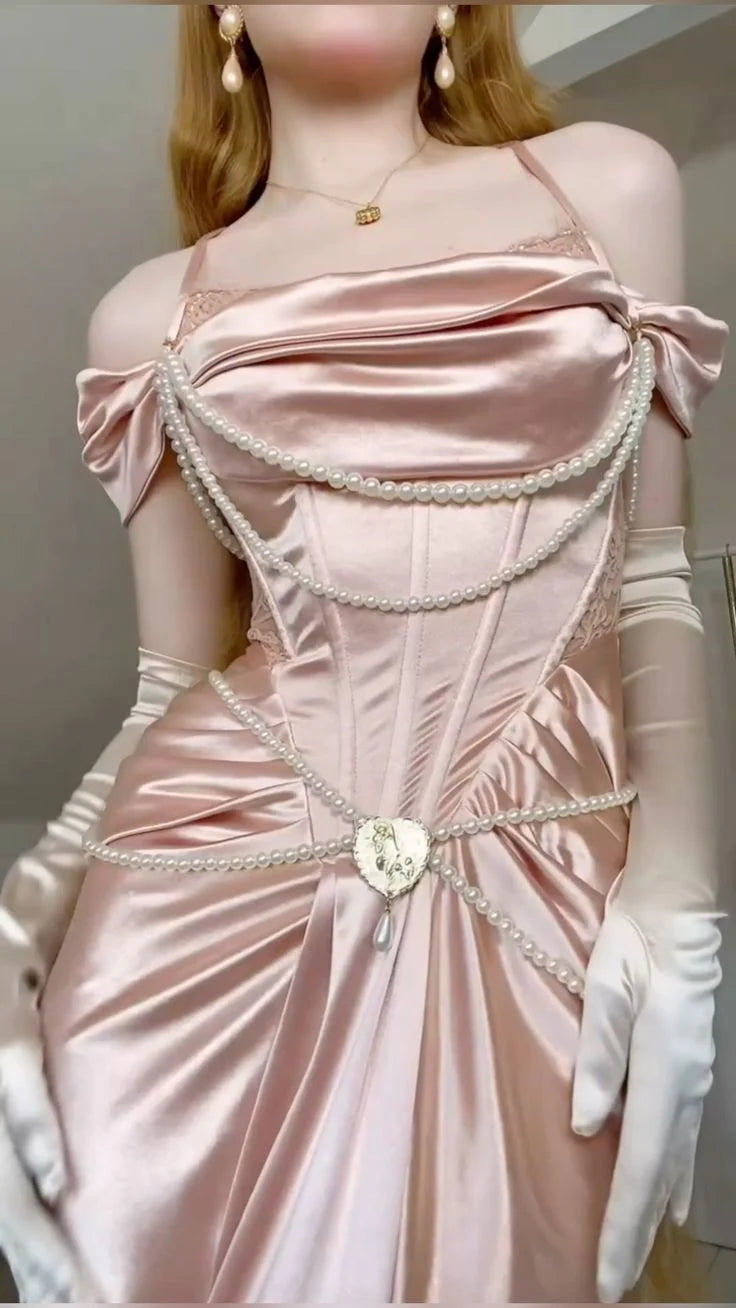 参考知识 21/1000  机翻 · 通用领域 A light pink satin dress with an open shoulder strap design and a high slit skirt