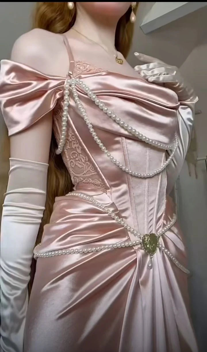 参考知识 21/1000  机翻 · 通用领域 A light pink satin dress with an open shoulder strap design and a high slit skirt